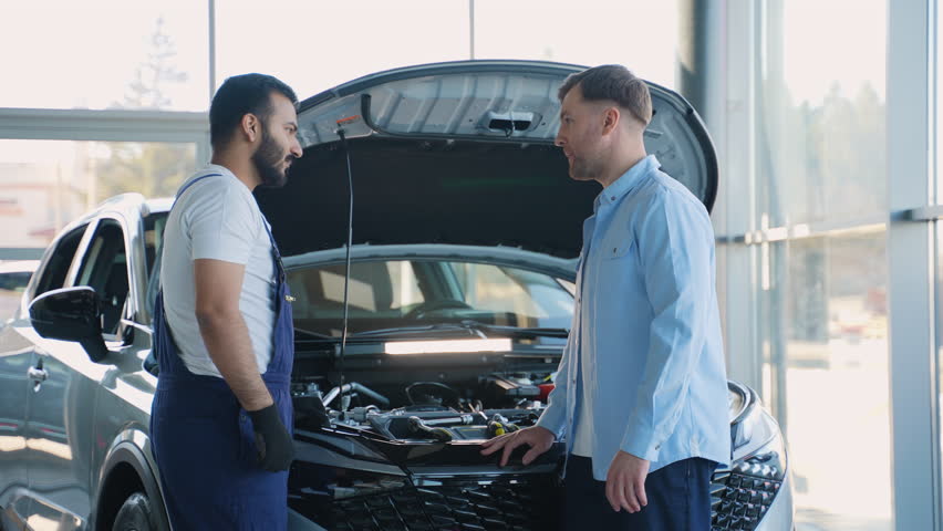 Indian mechanic explaining engine problem to a customer shaking hands