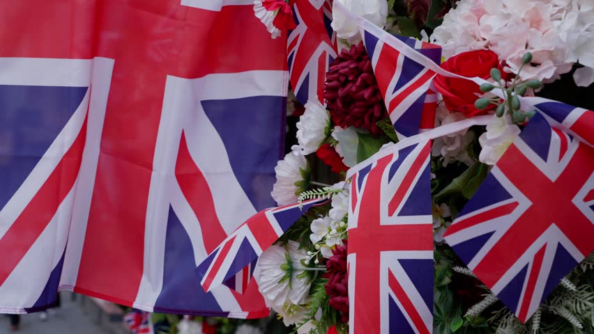 British flags waving among flowers in Cambridge, celebrating a national event