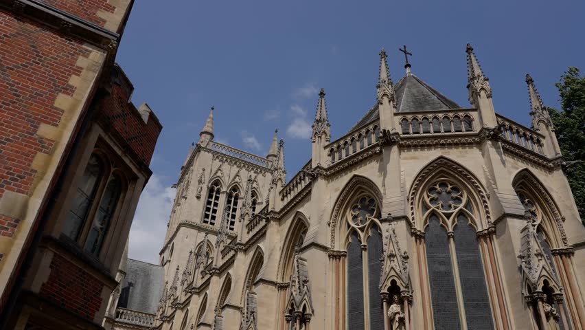 Architectural detail of St. John s College Chapel in Cambridge, UK, showcasing its intricate gothic style against a vibrant blue sky