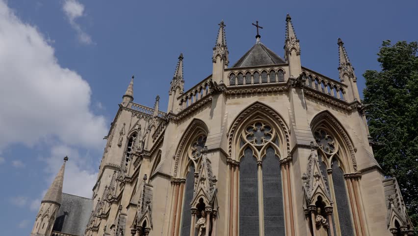 Architectural detail of Selwyn College Chapel in Cambridge, UK, showcasing gothic revival style against a partly cloudy sky