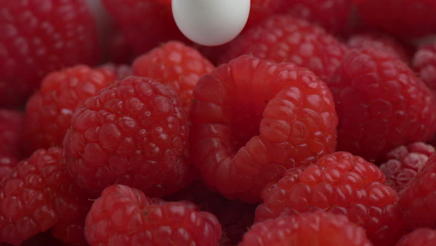 Cream pouring over fresh red raspberries in super slow motion.  Shot on the Phantom Flex 4K high speed camera at 1000 frames per second. 