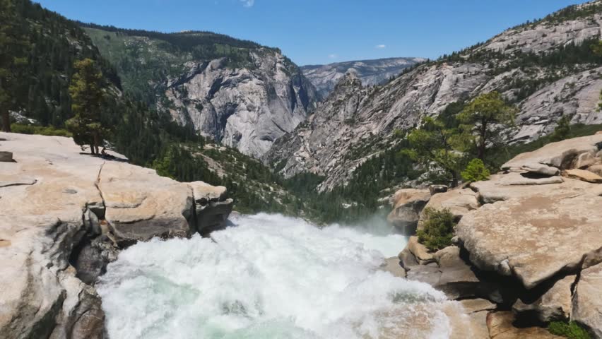  Breathtaking footage captured at the top of Nevada Fall, where the Merced River rushes across smooth granite before plunging into the canyon below