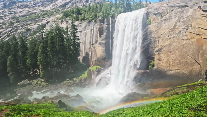 Beautiful view of Vernal Fall waterfall in Yosemite National Park, California, featuring rushing water, granite cliffs, forest scenery, and pristine wilderness landscapes