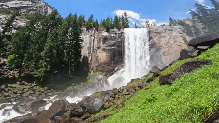 Beautiful view of Vernal Fall waterfall in Yosemite National Park, California, featuring rushing water, granite cliffs, forest scenery, and pristine wilderness landscapes