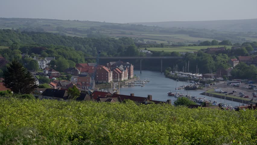 Panoramic view of Whitby harbor with boats and bridge connecting the two sides of the river Esk in North York Moors National Park, United Kingdom
