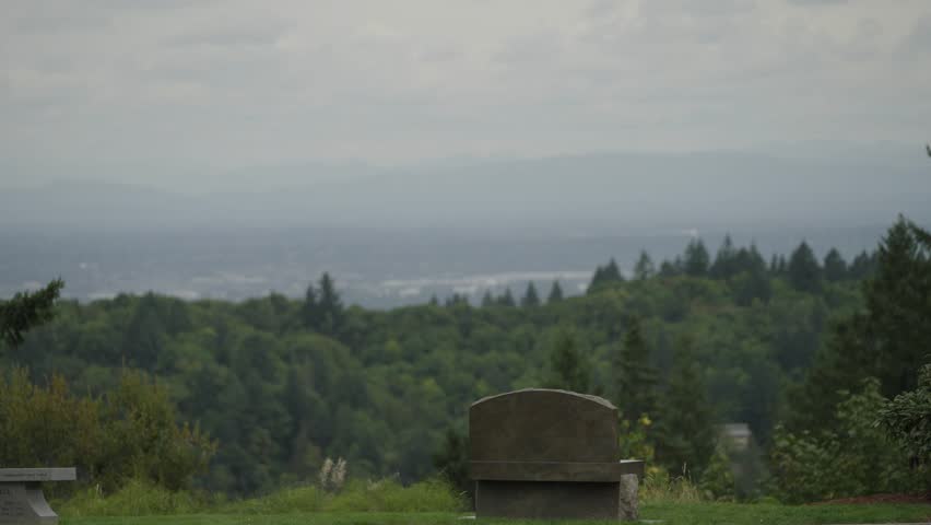 A lonely stone bench overlooks cloudy Portland, Oregon