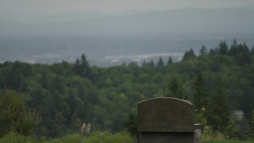 A lonely stone bench looks out at overcast Portland, Oregon