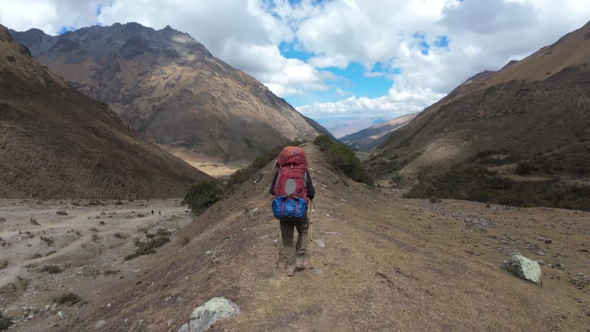 Hiker Walking On Ridge During Salkantay Trek In The Peruvian Andes Mountains