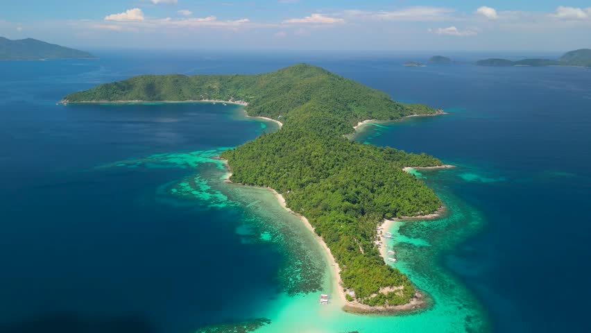 High altitude pullback from Maxima Island Port Barton Palawan revealing distinctive star-shaped jungle island with turquoise reefs and deep blue ocean
