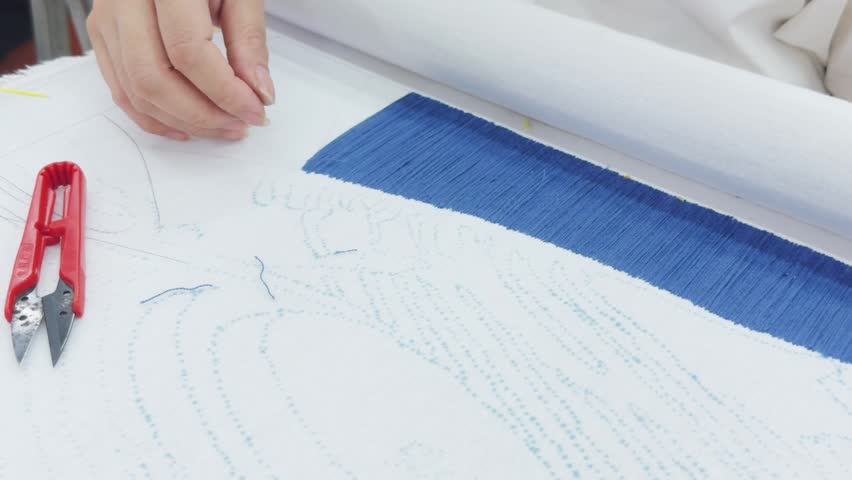 Hand working on a textile piece, a craftsman