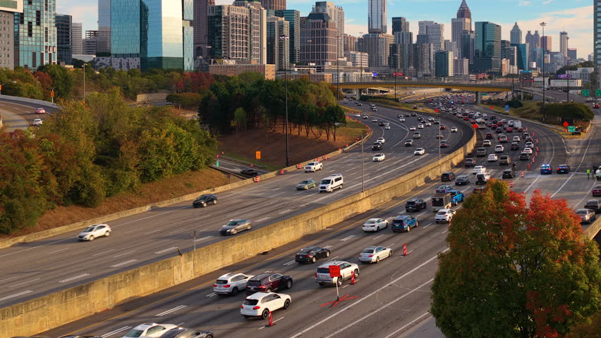 Urban Atlanta cityscape with modern skyscraper buildings and driving traffic on elevated interstate highways. American transportation system and metropolitan mobility.