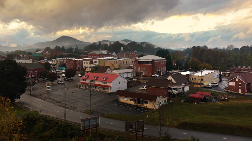Aerial landscape of Franklin town center at dusk with illuminated tourist streets and Great Smoky Mountains scenery. North Carolina travel destination.