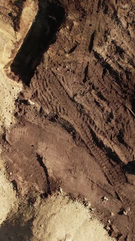 Aerial view from above of an excavator operating at dawn.