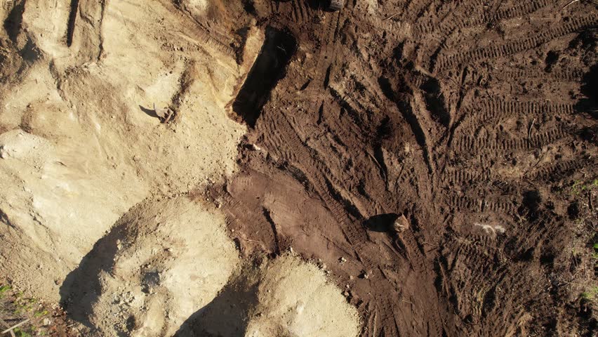 Aerial view from above of an excavator operating at dawn.
