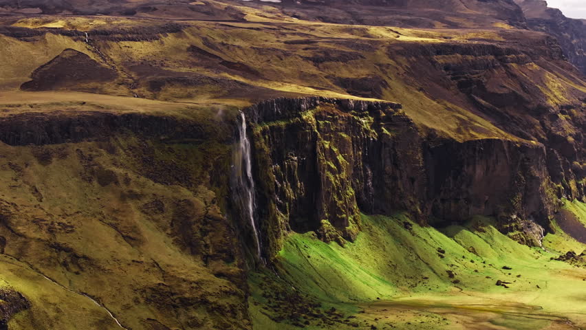 Seljalandsfoss iconic waterfall plunging over rugged cliff in Iceland. Aerial
