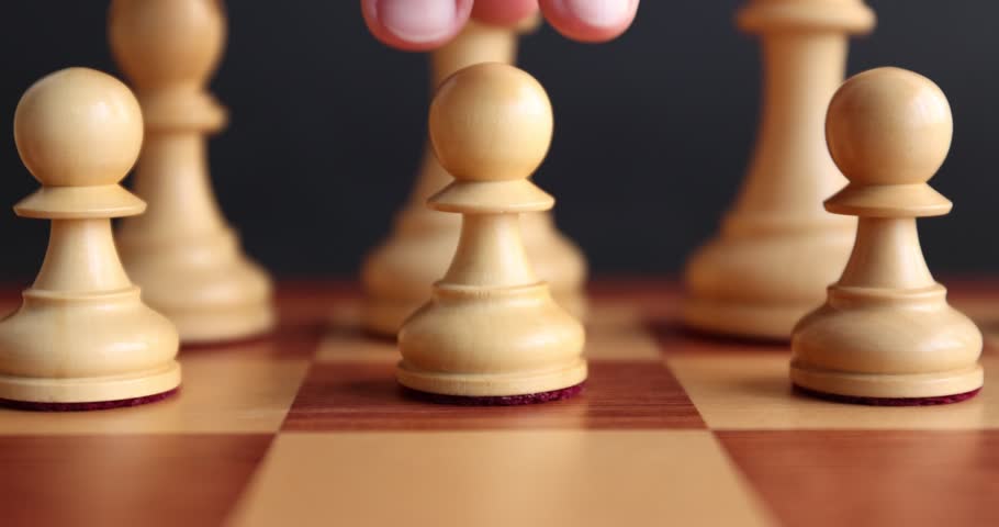 Playing chess. Man making first move with pawn, closeup. Camera moving backwards