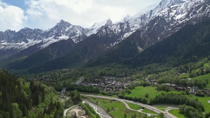Aerial view of the town of Chamonix nestled in the lush green valley surrounded by snow-capped peaks of the Mont Blanc massif in Chamonix, Auvergne-Rhone-Alpes, France.