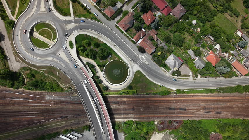 Aerial drone shot showing the intricate design of a highway bridge crossing railway lines in Kaposvár, Hungary, during daytime.