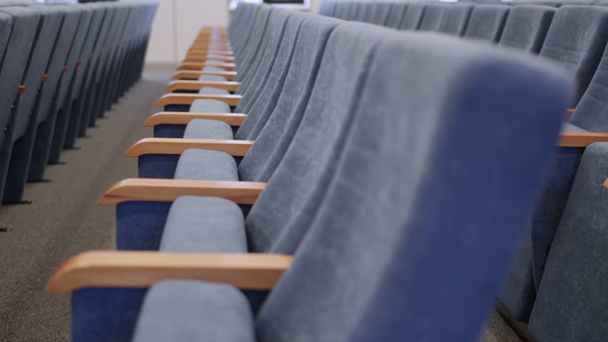 Uniform rows of comfortable conference furniture in lecture hall. Clean layout provides organized and structured academic environment