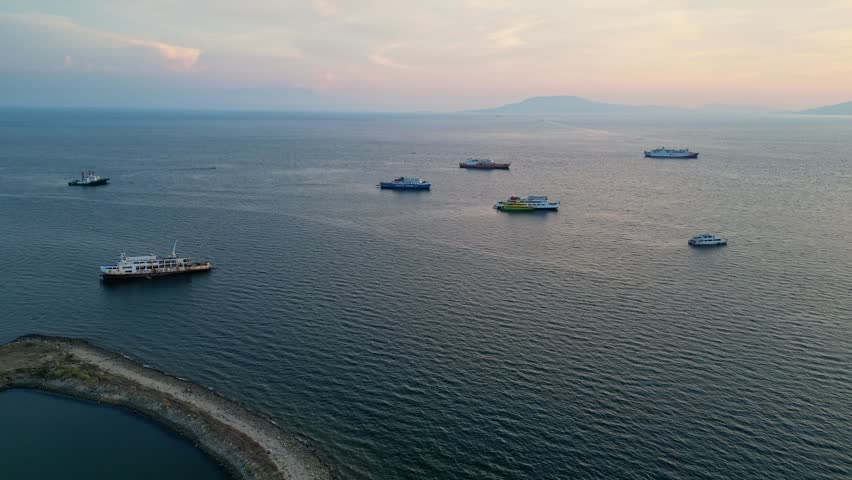 Slow forward aerial shot establishing shot of fishing boats parked along the shoreline at Batangas Bay of Wawa Batangas City Philippines.