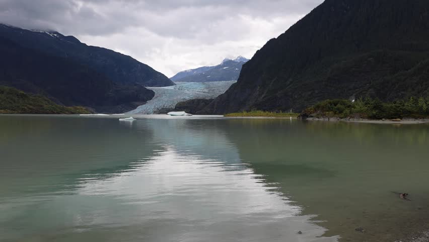 View of Mendenhall Glacier and the surrounding mountains reflected in the lake Juneau, Alaska, United States.