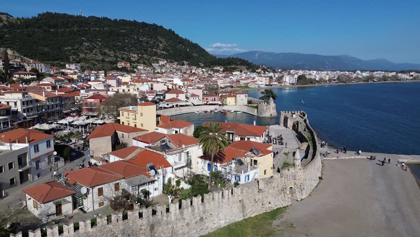 Nafpaktos, Aetolia Acarnania, Western Greece - March 15th, 2026 - aerial and street footage of the historical town, venetian harbor, venetian castle and fortress, clock tower, architecture, boats, former mosques, beaches and the landscapes around