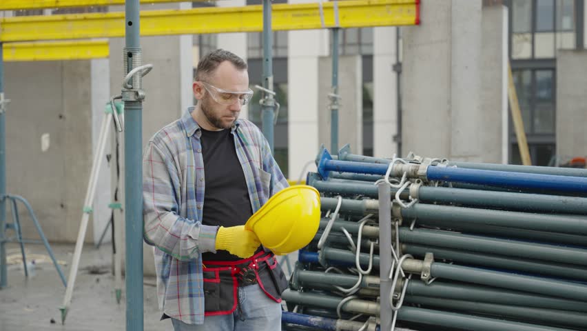 Construction worker putting on hard hat and giving orders