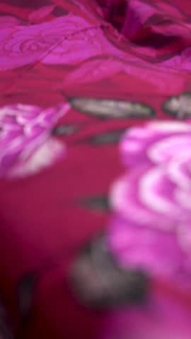 Elegant pink rose floral pattern on dark magenta fabric a vertical view of a luxurious featuring layered roses and soft white
