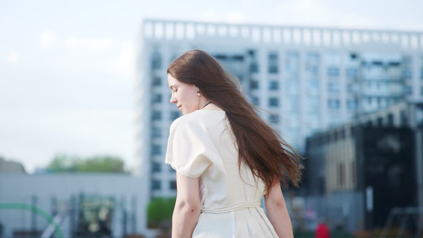 Young woman in white dress with city skyline background