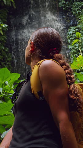 Close Up of Female Hiker Watching Jungle Waterfall During Rainforest Adventure in Tropical Wilderness.