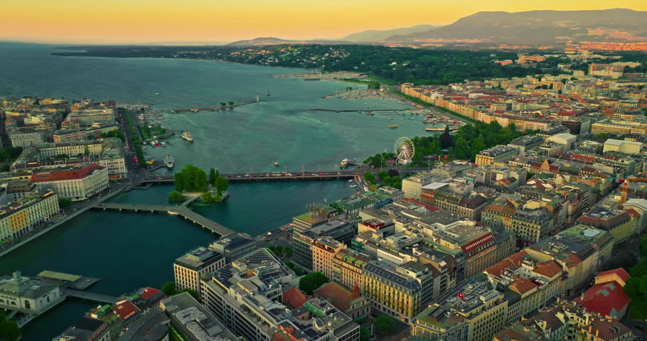 Establishing shot of Geneva city. Aerial view of the Swiss lake town. Rooftops of houses and the lake bay