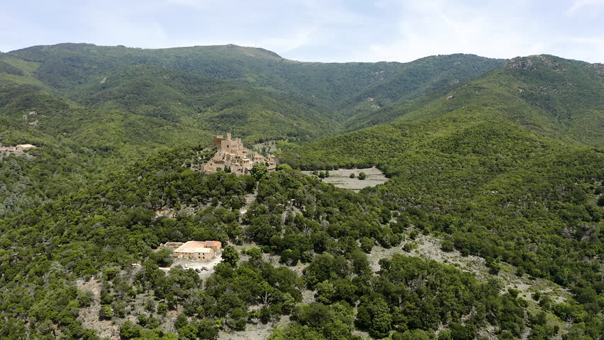 Aerial view of Montsoriu Castle, one of the finest medieval fortresses in Catalonia, standing atop a wooded hill and dominating the landscapes of the Montseny Natural Park. 