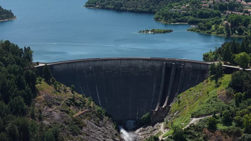 aerial - Ermal dam concrete wall with blue reservoir and forested hills in Vieira do Minho Braga Portugal