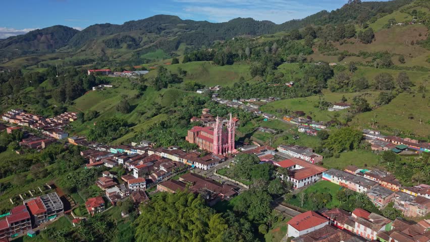 Aerial view of Jerico town center with colorful buildings and large church, lush hills