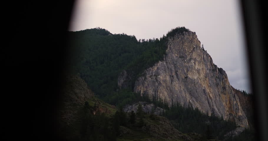 Rocky mountain cliff viewed through car side window