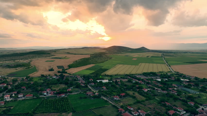 Aerial view of a traditional Bulgarian village and agriculture fields at sunset
