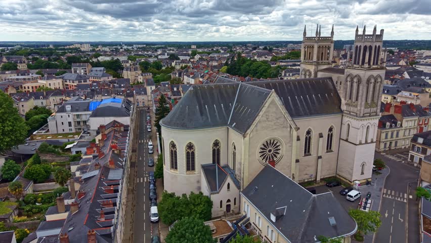 Saint Joseph Church dominates the skyline of Angers, Maine et Loire, Pays de la Loire, France, surrounded by historic streets, residential blocks and civic buildings, drone lateral slide right shot.