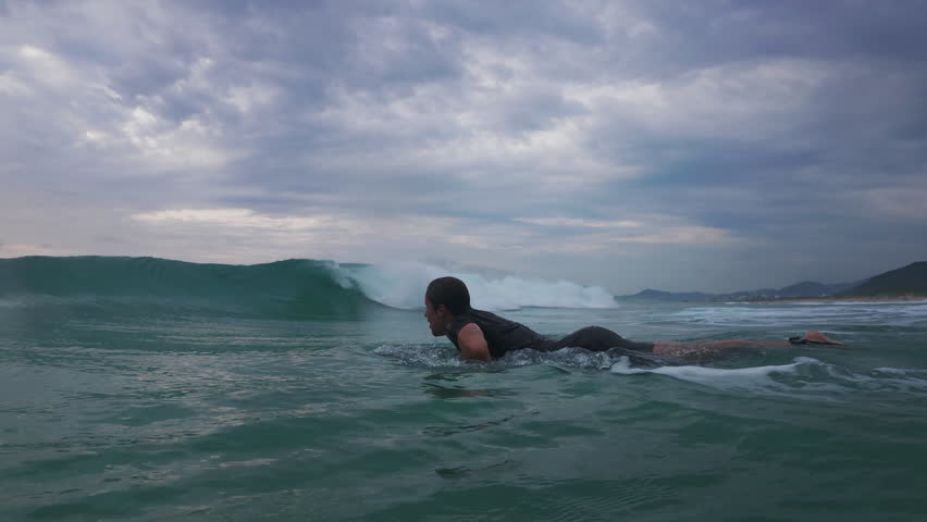 Surfer dives under the wave. Underwater footage of the surfer diving under the wave with surfing board
