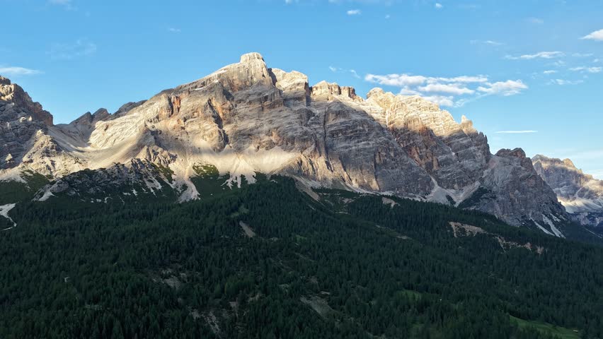 Cinematic hyperlapse flight through the dramatic peaks of the Dolomites, Italy. Morning light reveals rugged alpine cliffs, dense forests, and breathtaking mountain scenery in the Italian Alps.