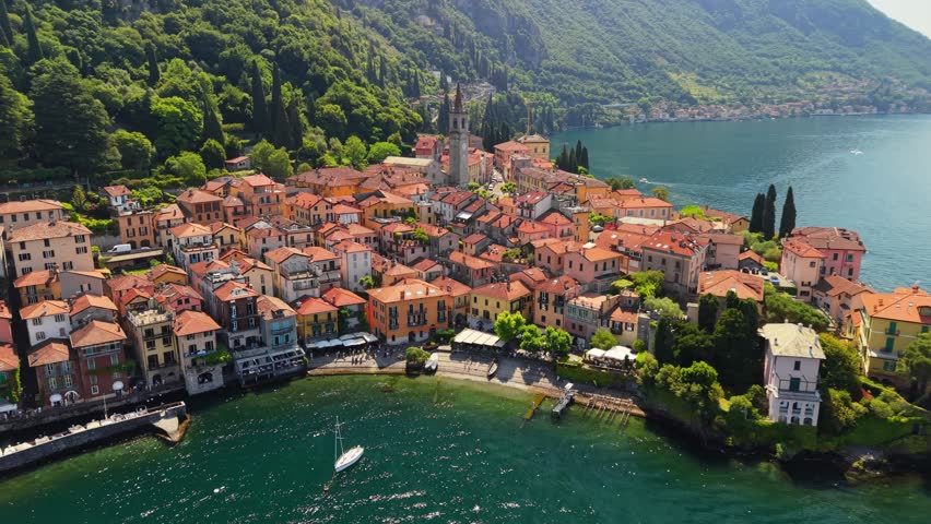 Aerial view of Varenna town on the shore of beautiful lake Como. Colorful traditional houses line the waterfront in Italy. Varenna village surrounded by blue waters