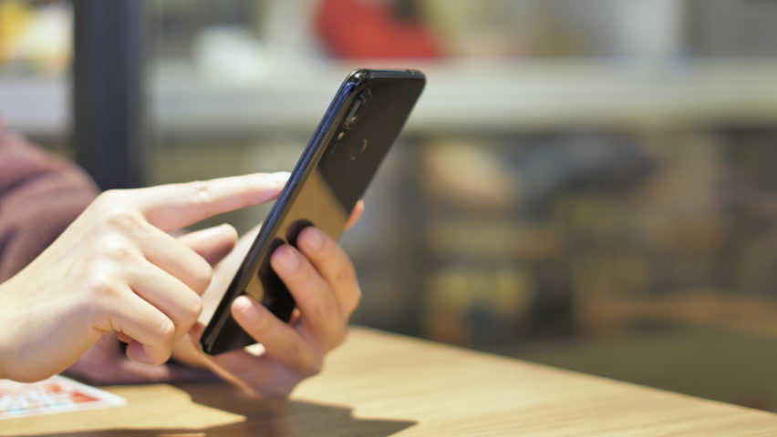 Asian women from East Asia, including China, use their mobile phones to communicate in a shopping mall.