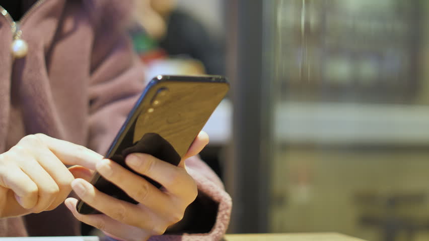 Asian women from East Asia, including China, use their mobile phones to communicate in a shopping mall.