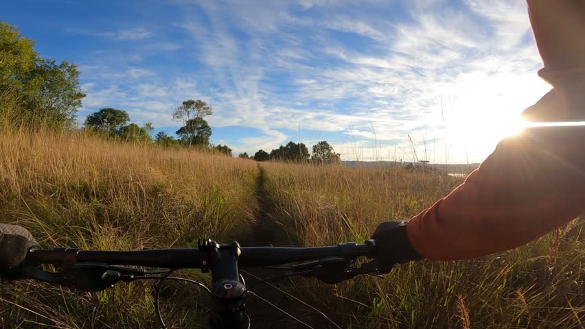First-person view of a cyclist on a nature trail.