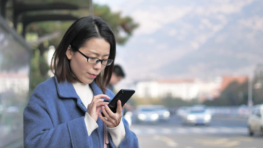 Asian women from East Asia, including China, use their mobile phones to communicate in a shopping mall.
