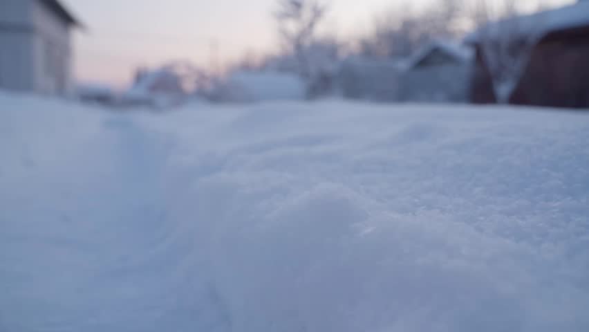 Snow covered rural village street in winter at dusk close-up