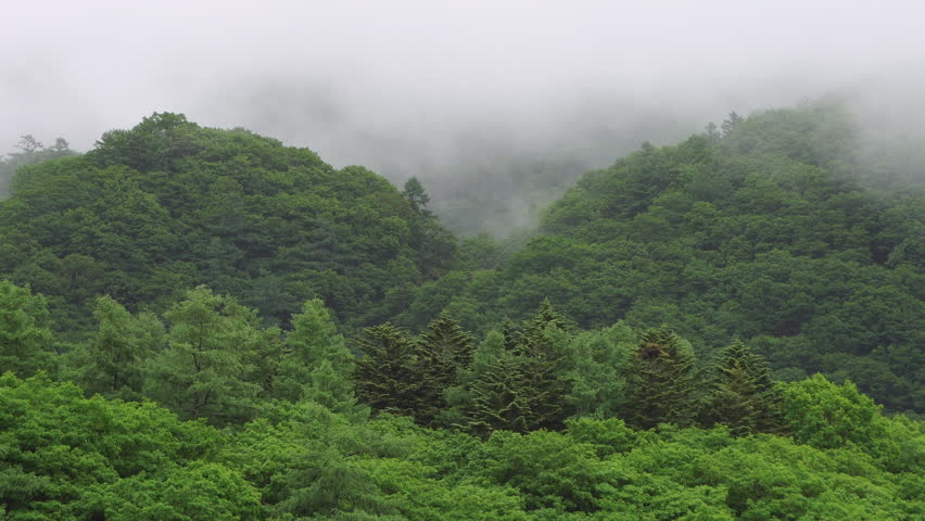 A mountain landscape with clouds drifting across a cloudy sky
