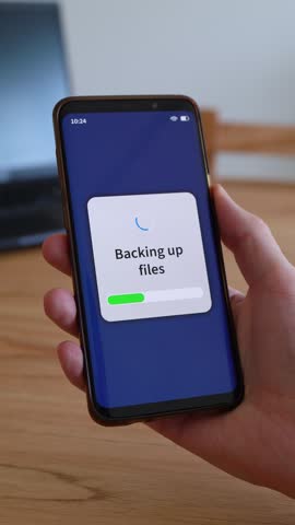 Backing up smartphone files on cloud storage. Concept of backup. Vertical shot.