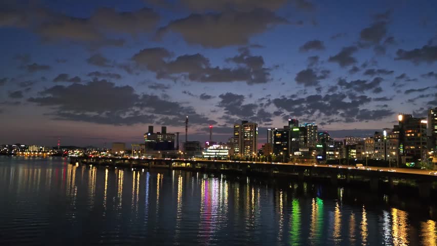 Night cityscape of Seoul under a beautiful cloudy sky with water reflections