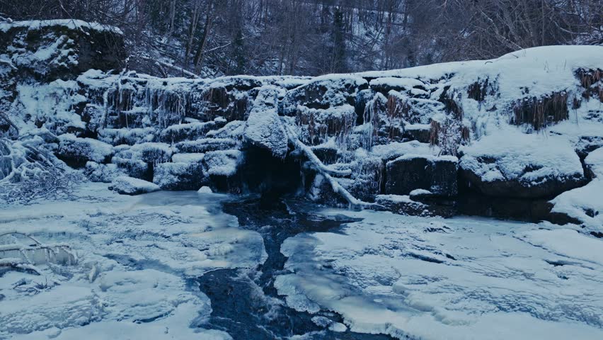 Stream Rushing In Rocky Snowscape River In Winter Forest. Approach Shot