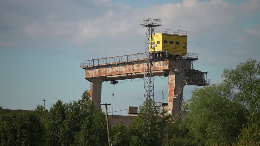 Abandoned shipyard with old rusty cranes near the sea.